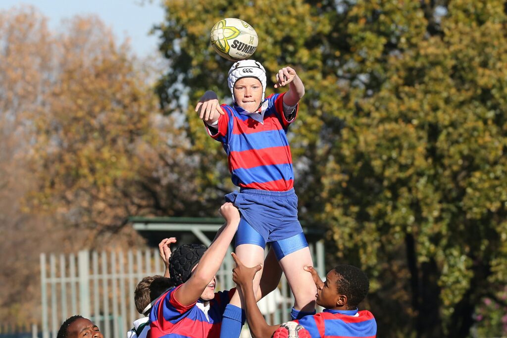 Young rugby players in a fierce game moment outdoors, capturing teamwork and sport intensity.